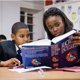 School children reading a text book