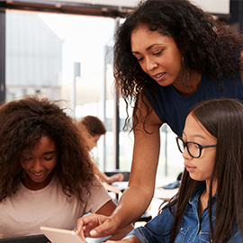 two students with an older lady, possibly teacher