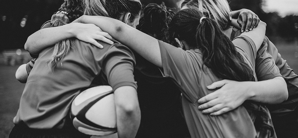 Group of teens in huddle after rugby game