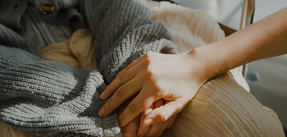 Two people holding hands in support