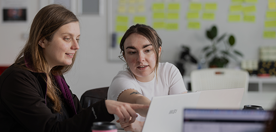two students working on a laptop