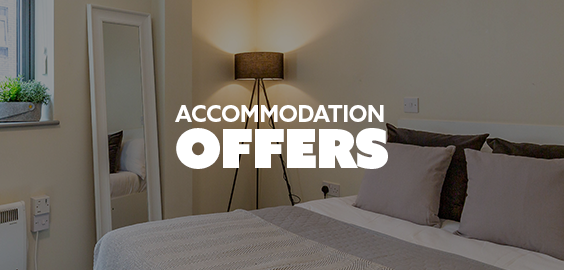 A neatly made bed in a student bedroom beside a light floor lamp and tall mirror. Text reads 'accommodation offers'