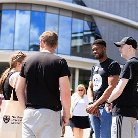 Students chatting outdoors on Northumbria University campus during an open day