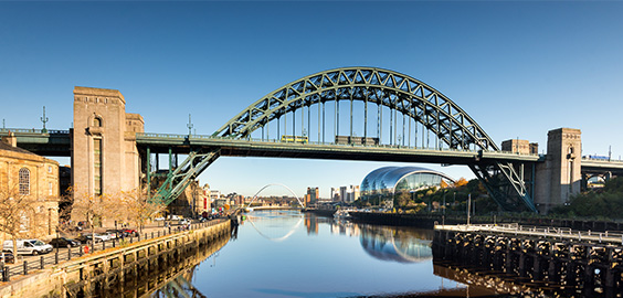 Newcastle quayside image taken from behind the Tyne bridge, showing the river Tyne and the bridges 