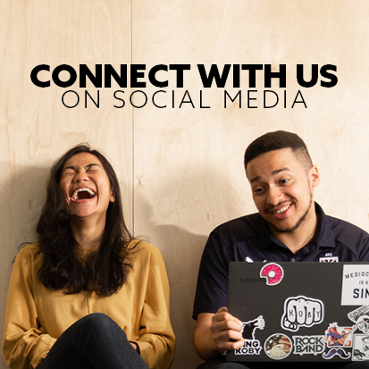 a woman in a yellow jumper is laughing against a wood background, a man with a laptop on his knee laughs and shrugs. text reads connect with us on social media