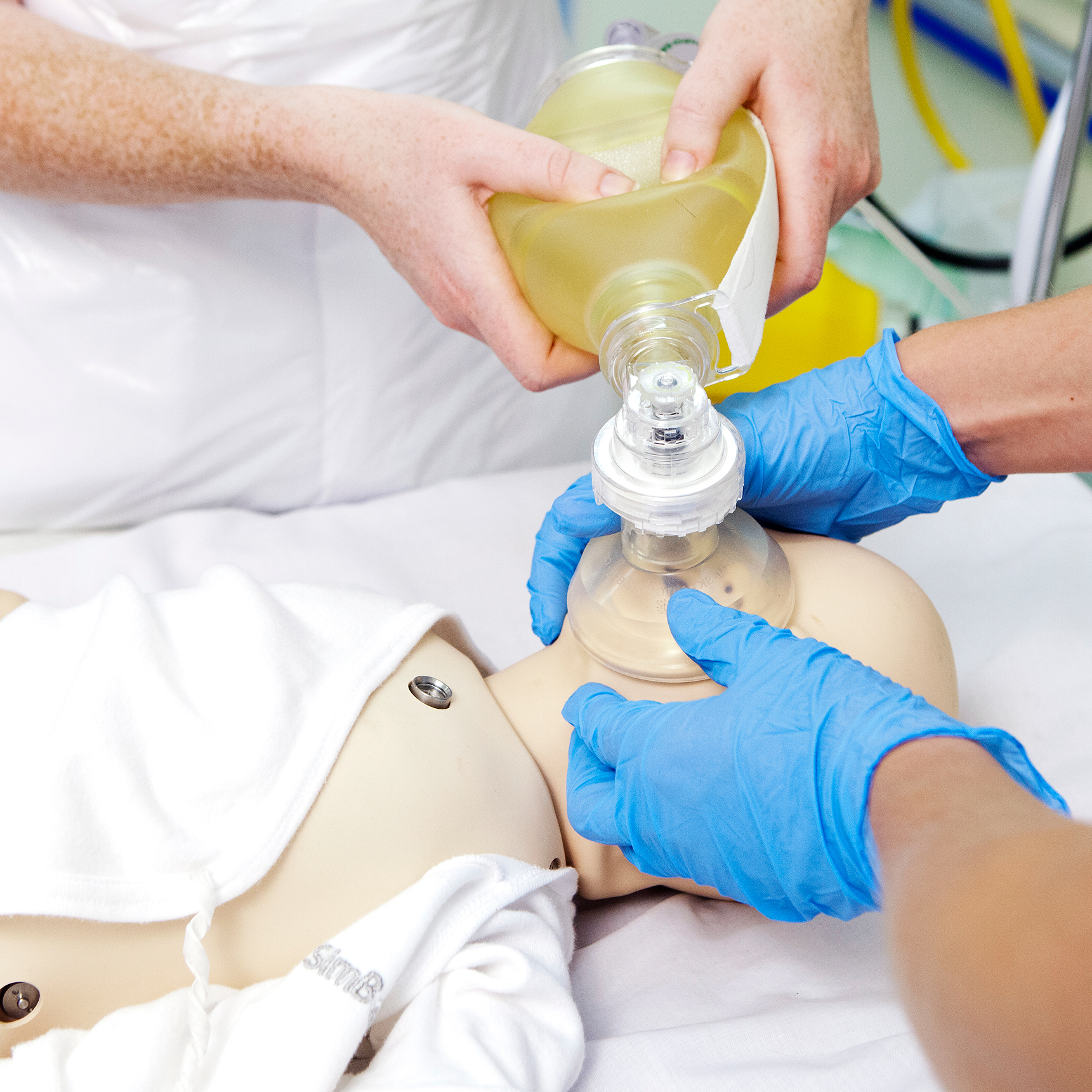 Two nursing students use a ventilator to practice treatment on a dummy