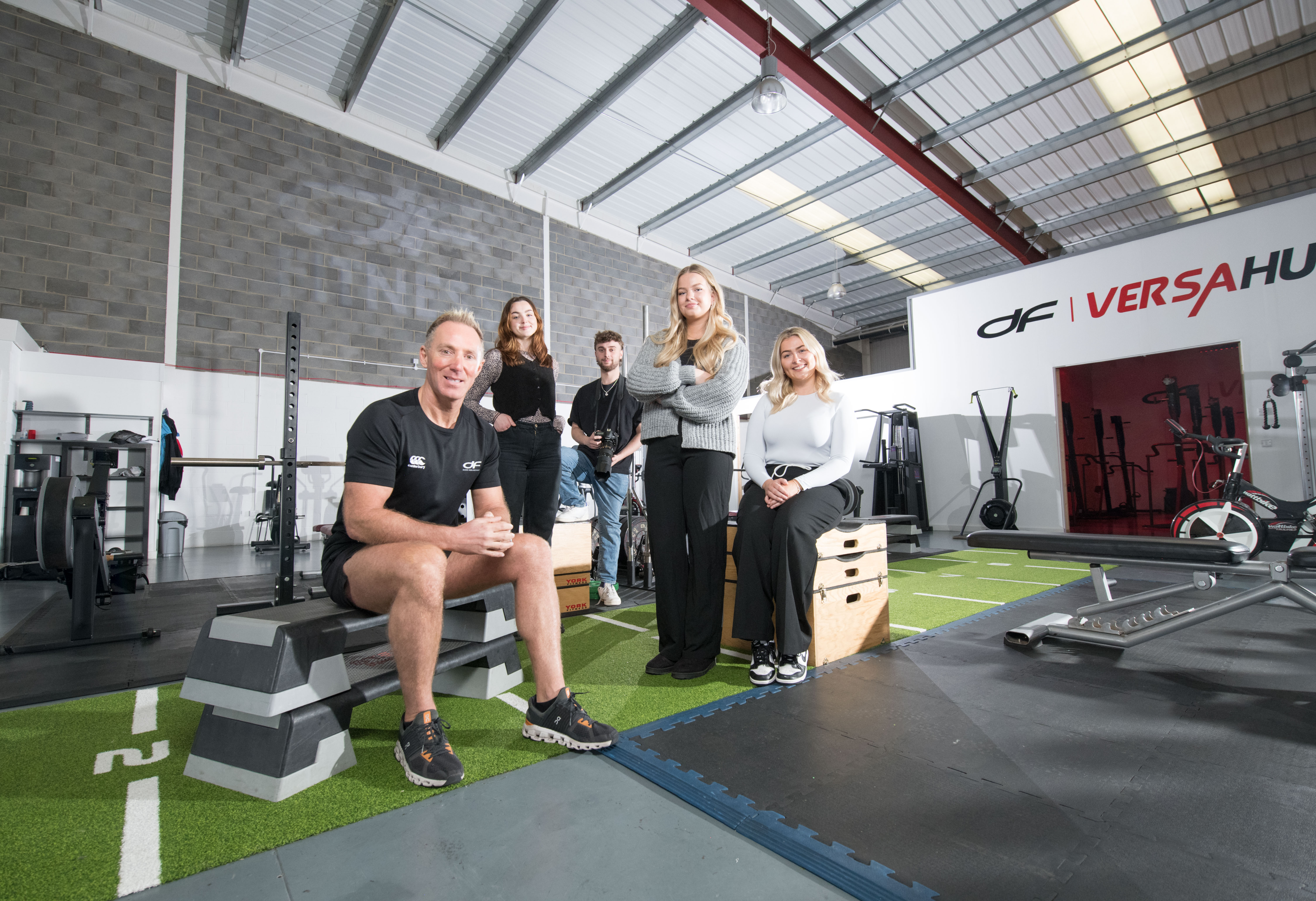 Image of a group of people in a gym smiling at the camera
