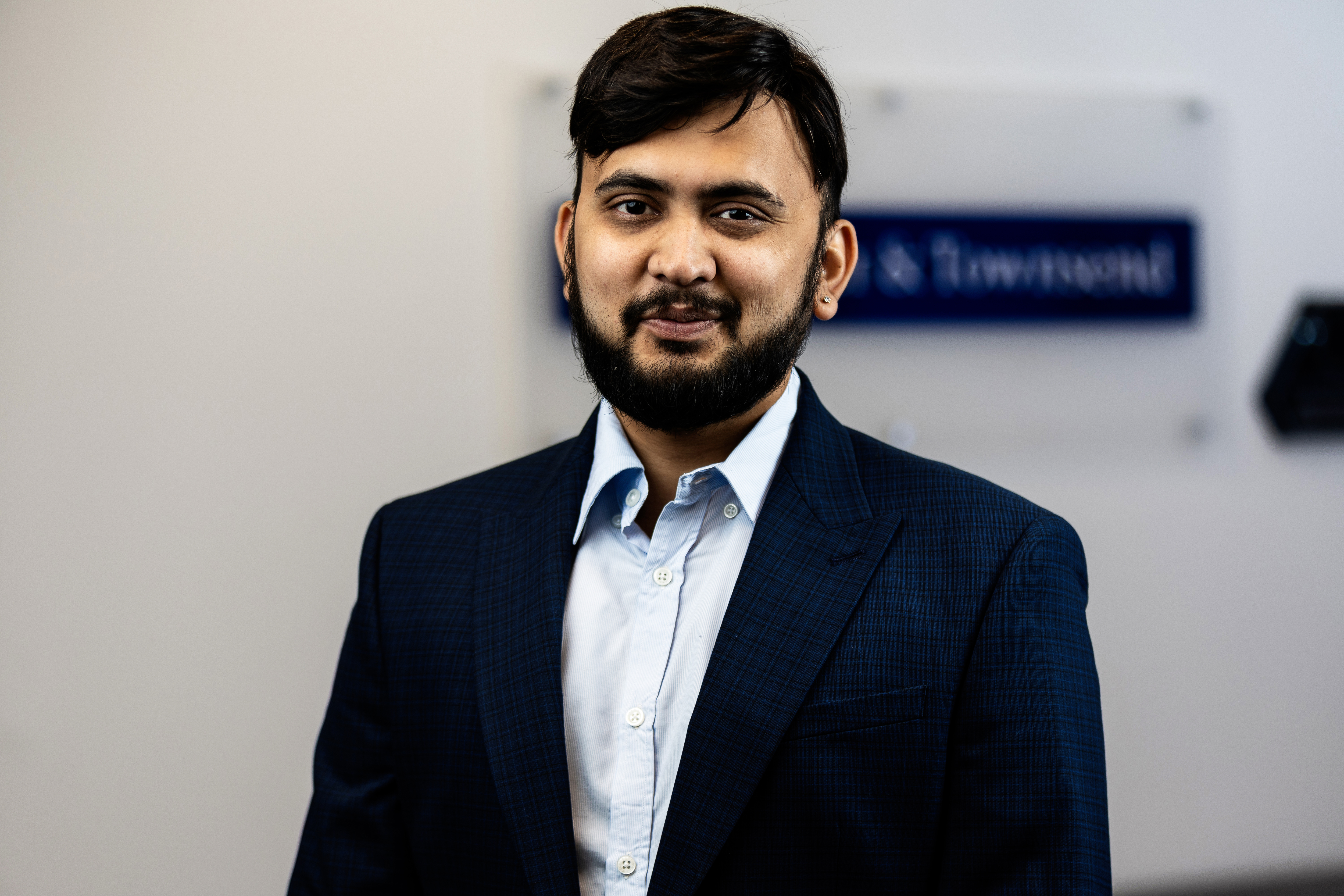 Man wearing a black suit smiling at the camera