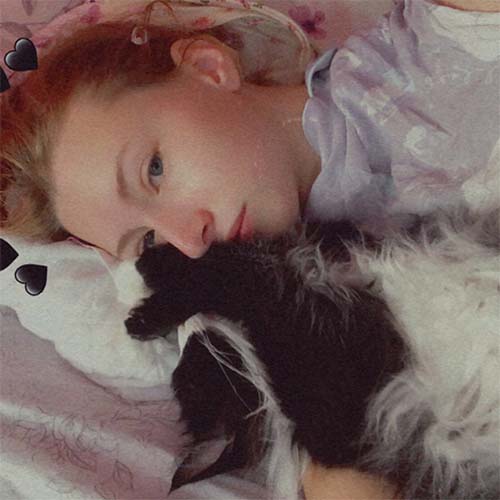 A picture of Ryan cuddling with her sister's cat, Styles.