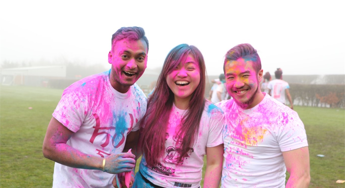 group of people smiling covered in paint