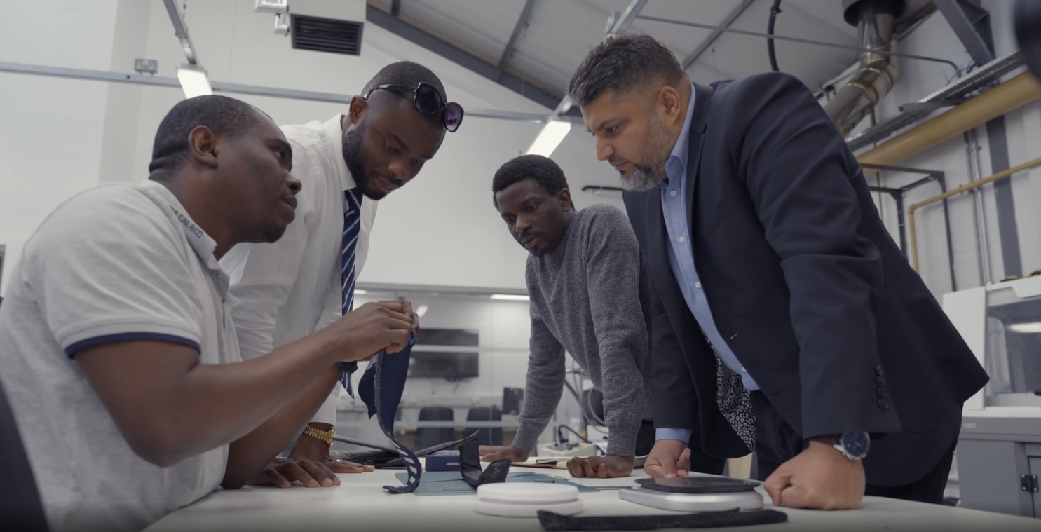 Group of men standing around a talking