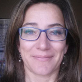 a woman wearing glasses and smiling at the camera
