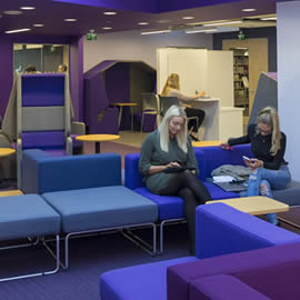 2 students reading in library