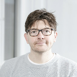 a man wearing glasses and looking at the camera