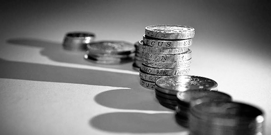 Black and white image of pound coins in a stack.