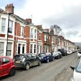 terraced street lined with cars