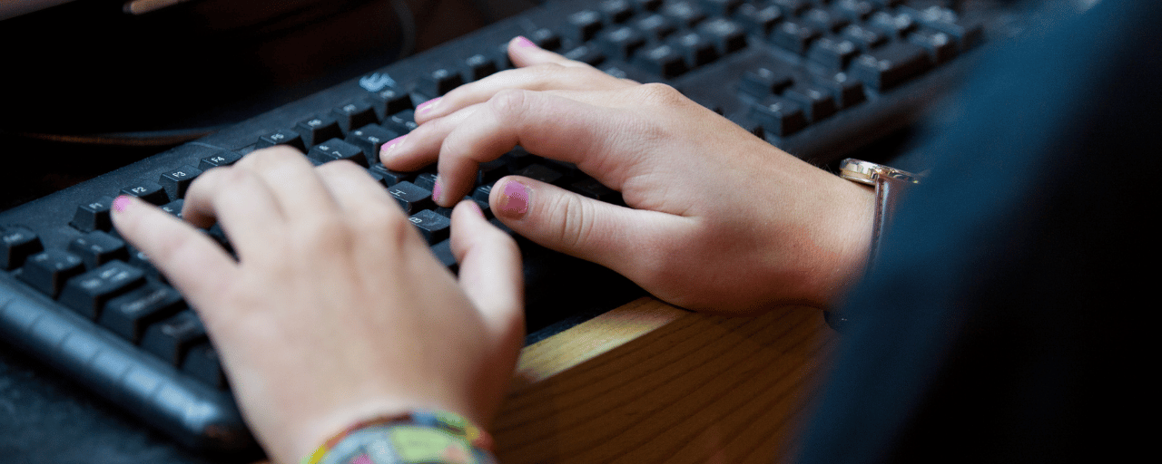 Close up of hands writing on a keyboard