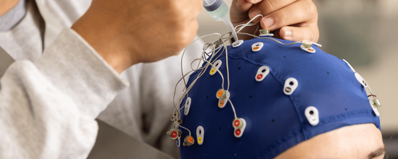 person with blue medical cap on with wires attached