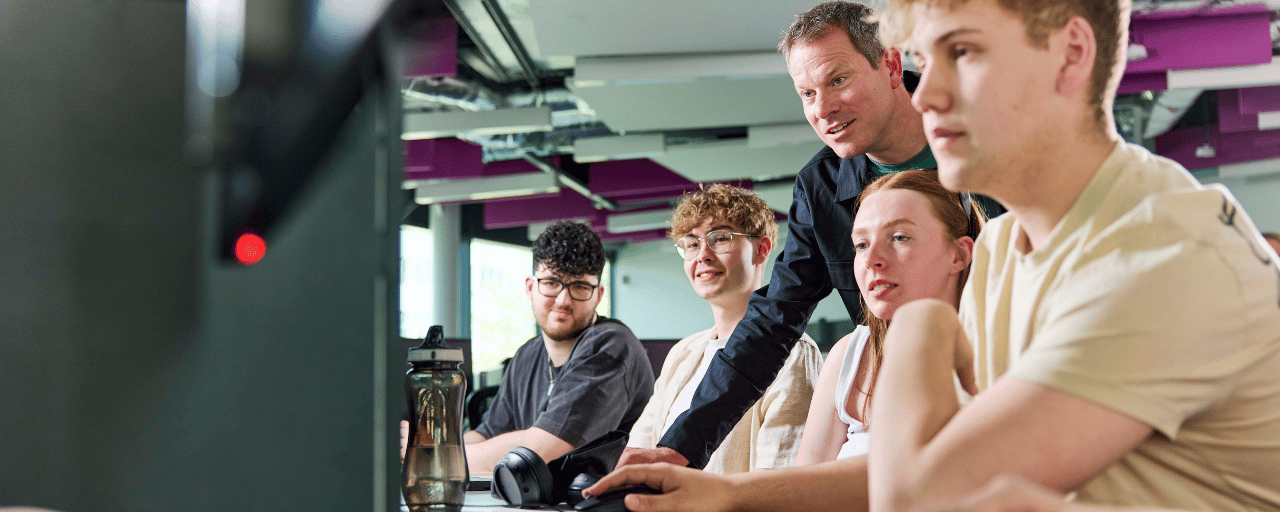 computer science students working together with help of staff