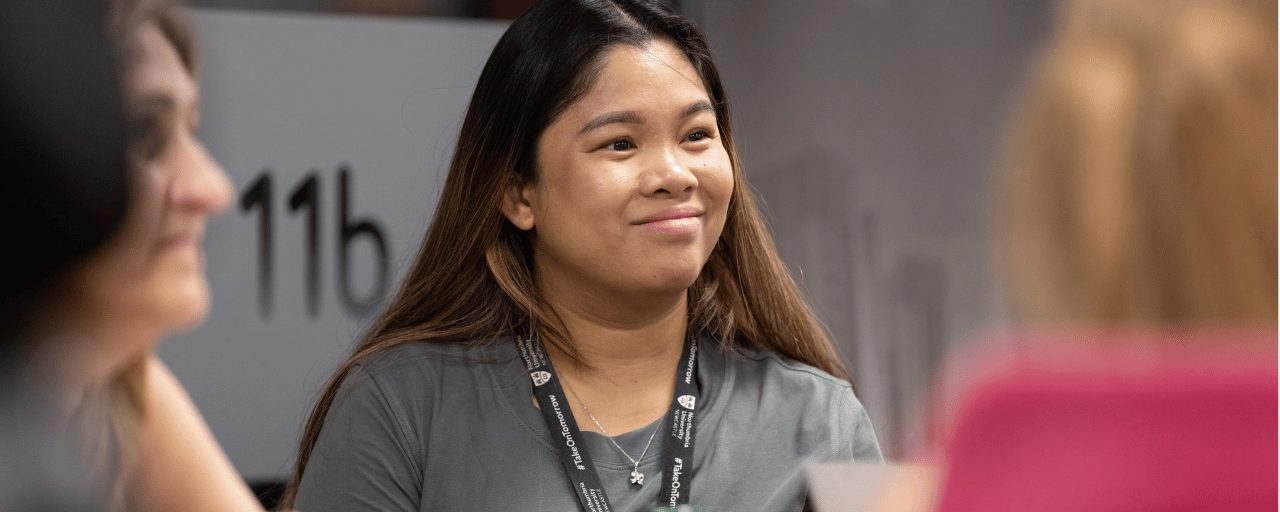 close up of student smiling with peers around her
