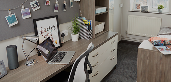 a bedroom with a bed and desk in a room