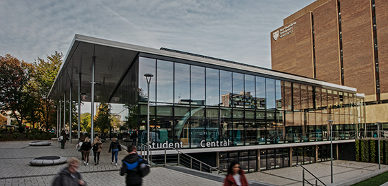 a group of people walking down a sidewalk in front of a building