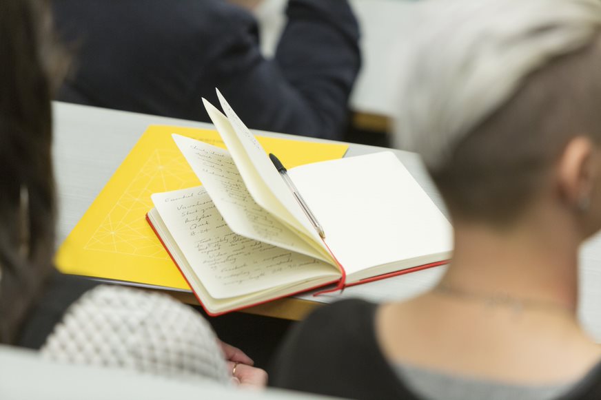  book on table in front of girl with short and styled grey hair