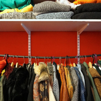 rack of clothes with a red backdrop