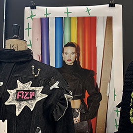 Fashion items and image of a model - includes two black jackets and colourful rolls of fabric