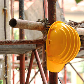 A yellow hard hat resting on scaffolding