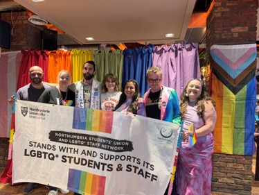 Members of the Northumbria Students' Union and LQGTQ+ Staff Network holding a banner with the words "Northumbria Students' Union and LGBTQ+ Staff Network stands with and supports its LGBTQ+ students and staff"