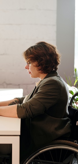 A woman in a wheelchair working at a desk