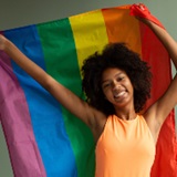 Young girl holding a rainbow flag 