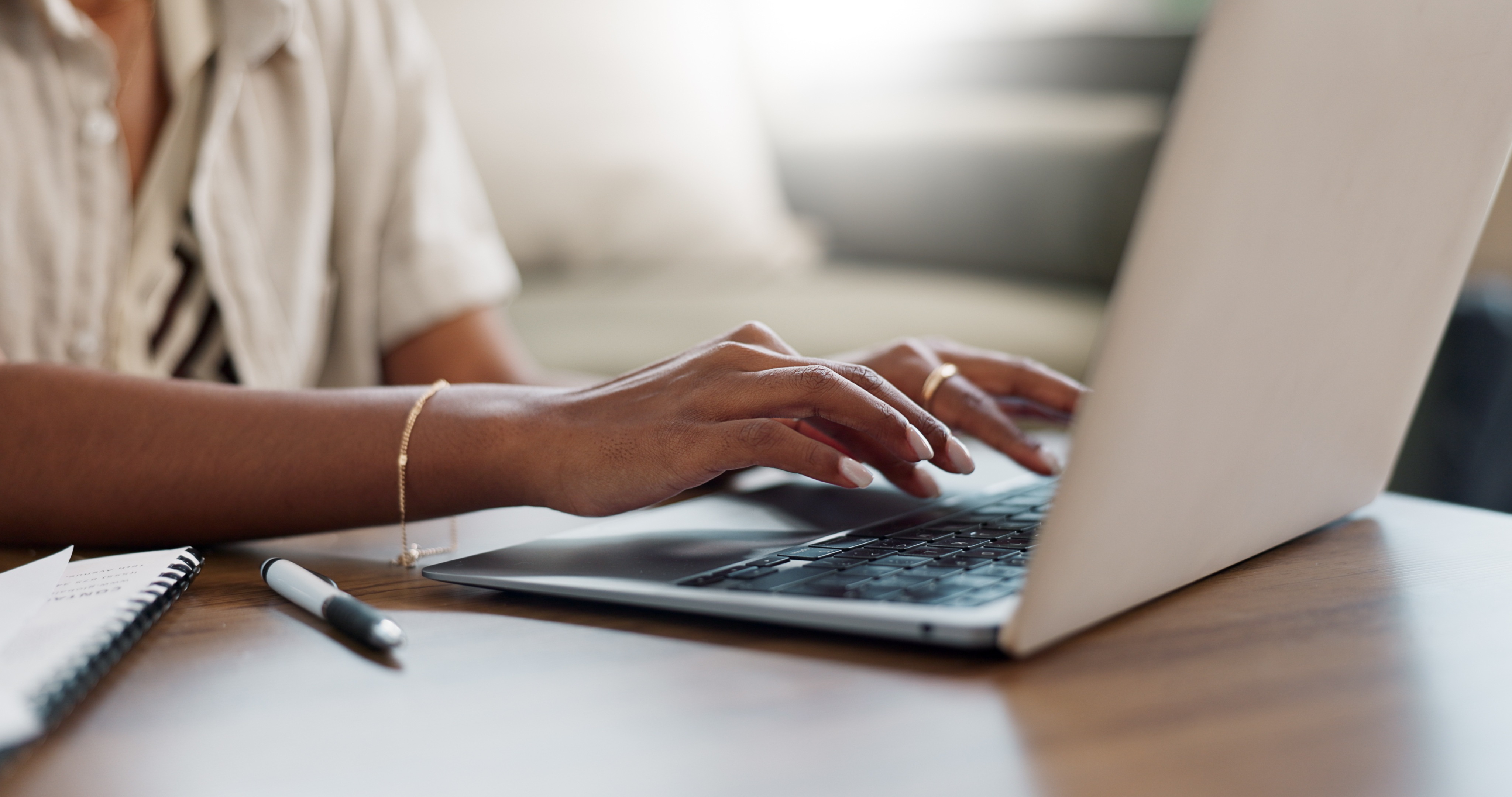 Hands typing on a laptop