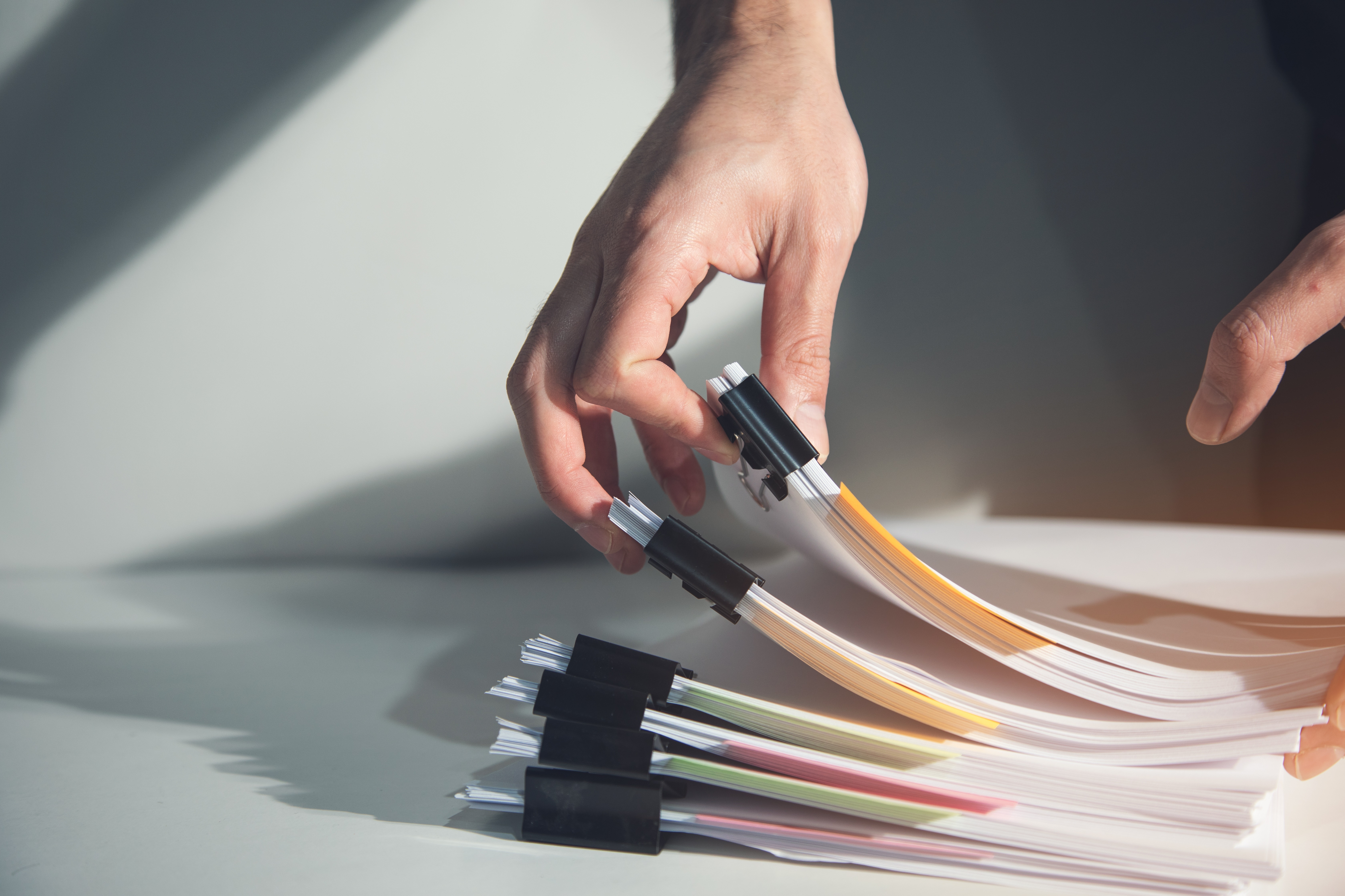 Image of a persons hand flicking through a stack of paper folders