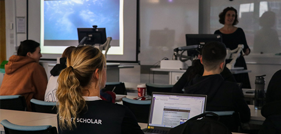 students in a seminar setting with an academic talking to them.