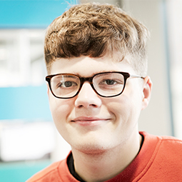 a man wearing glasses and smiling at the camera