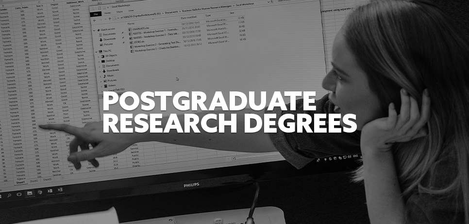 Student working on a project with white text 'Postgraduate Research Degrees' 