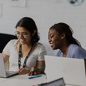 Two female students gathered around a Dell laptop.