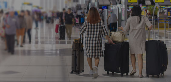 Image: People at airport with their suitcases