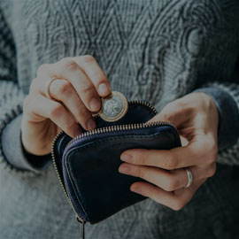 Female adding a coin into a black purse.