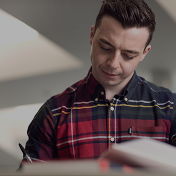 Close-up of a student making notes in a book