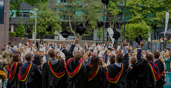 Group of graduates throwing their graduation caps in the air.