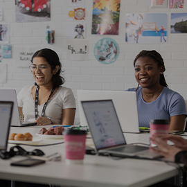 Two students working from laptops in the Communication Design Studio