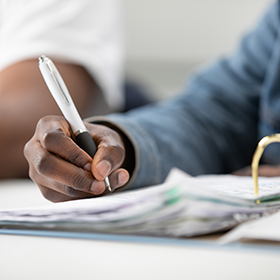 Close-up on a student writing in a file.