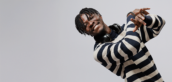 Student of West African decent laughing and dancing, looking directly at the camera as part of the 'I Am Northumbria' photoshoot campaign.