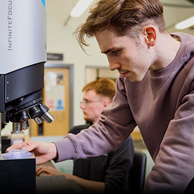 Engineering student using a microscope.