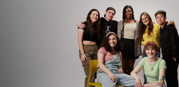 Image of a group of students of different nationalities and genders, huddled together and laughing against a white background as part of the 'I Am Northumbria' campaign.