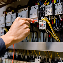 Close-up of an individual working on a fuse box.