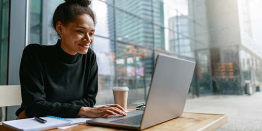 woman with laptop and book in city background